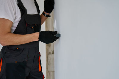 Midsection of man standing against wall