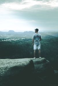 Rear view of man standing on rock