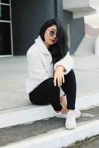 Full length of woman sitting in snow