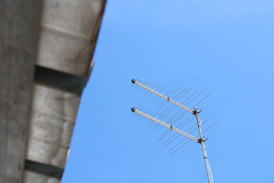 Low angle view of telephone pole against clear blue sky