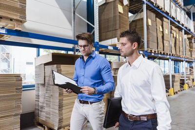 Two businessmen having a meeting in company warehouse