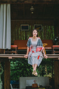 Portrait of woman standing against built structure