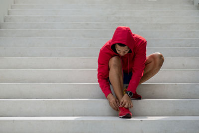 Full length of man tying shoelace on steps