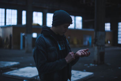 Young man standing in abandoned building