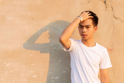 Portrait of boy standing against wall