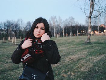 Portrait of young woman standing on land against clear sky