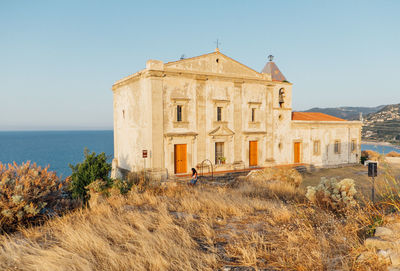 Building by sea against clear sky