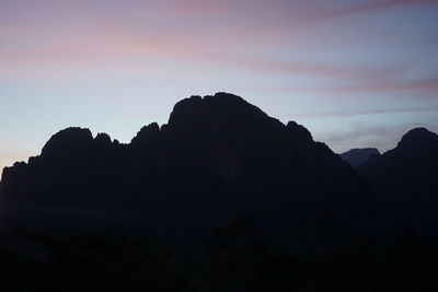 Scenic view of silhouette mountains against sky at sunset