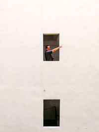 Man gesturing while standing by window