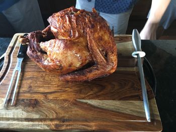 High angle view of roasted turkey on cutting board at kitchen counter
