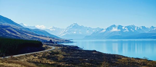 Scenic view of lake and mountains against blue sky