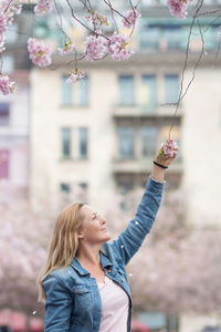 Young woman looking at camera while standing against plants