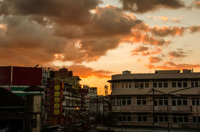 Buildings in city against cloudy sky