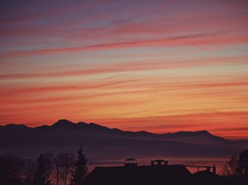 Scenic view of silhouette mountains against orange sky