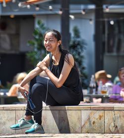 Portrait of a smiling young woman sitting outdoors