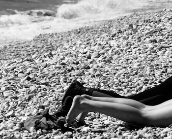 Low section of person on rock at beach