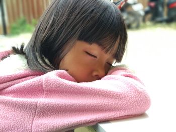 Close-up of girl sleeping on table