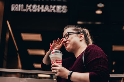 Portrait of young woman drinking glass