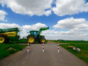 Car on country road against cloudy sky
