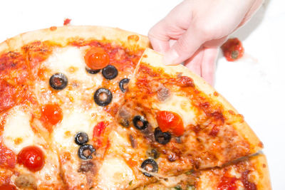 Close-up of hand holding pizza