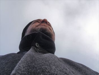 Directly below shot of man against cloudy sky