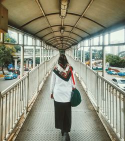 Rear view of woman standing on bridge