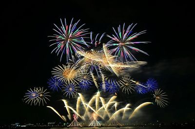 Low angle view of firework display against sky at night