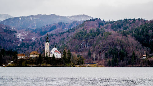 Scenic view of lake and buildings against sky