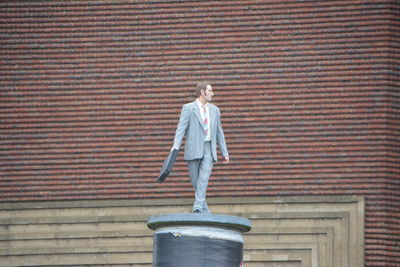 Low angle view of man standing against wall