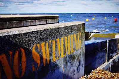 Close-up of retaining wall by sea against sky
