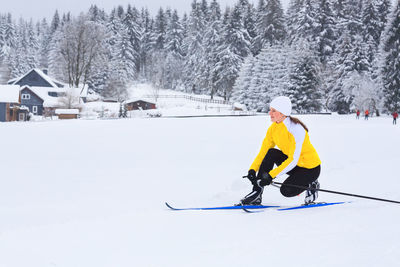 Full length of woman preparing for skiing