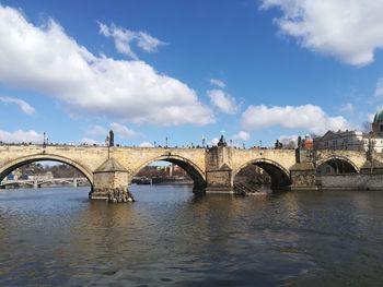 Arch bridge over river against sky