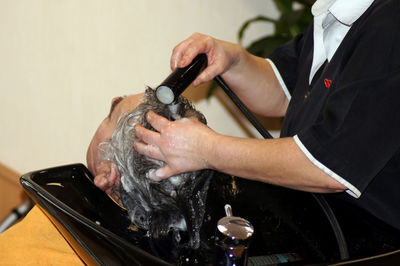 Close-up of man getting hair washed at salon