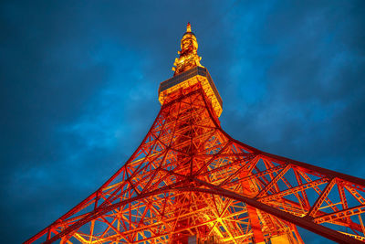 Low angle view of illuminated tower against cloudy sky