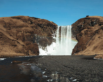 Scenic view of waterfall against clear sky