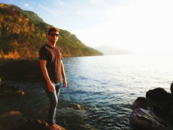 Portrait of man standing on rock against sea