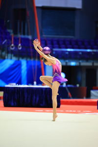 Little girl gymnast, performs various gymnastic exercises. the concept of childhood and sport