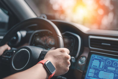 Cropped hand of man driving car