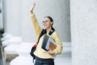 How to choose college or university. happy student girl with laptop and books near the university