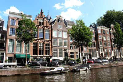 Boats in canal amidst buildings in city