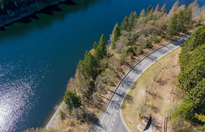 High angle view of road amidst trees and city against blue sky