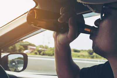 Midsection of man seen through car window