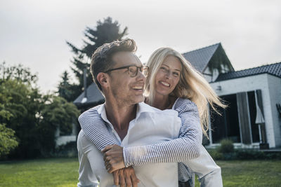 Happy couple embracing in the garden of their country house