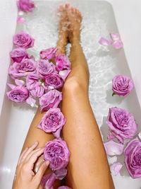 Personal perspective woman in the bathtub full of rose flowers