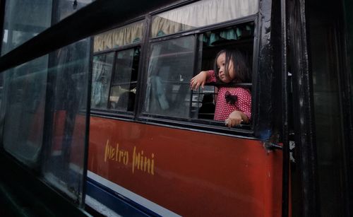 Rear view of woman looking through train window