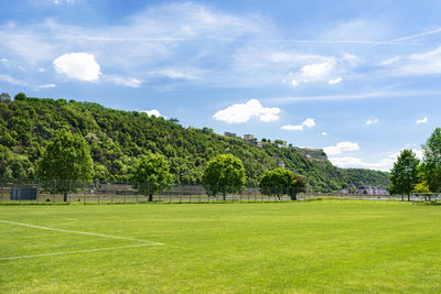 A football field located between the hills on a beautiful spring day, in the background a blue sky.