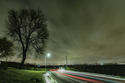 Light trails on road against sky at night