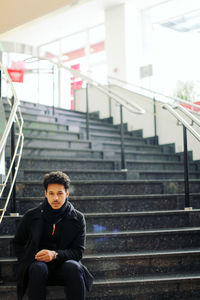 Young man sitting on staircase