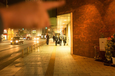 People on illuminated street at night