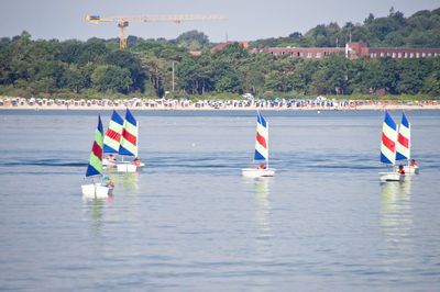 Sailboats in sea against sky